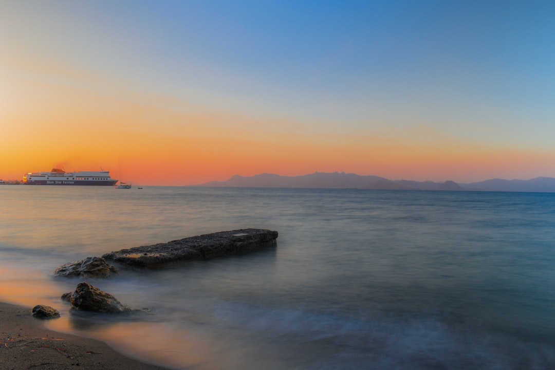 gray rock formation on sea during sunset
