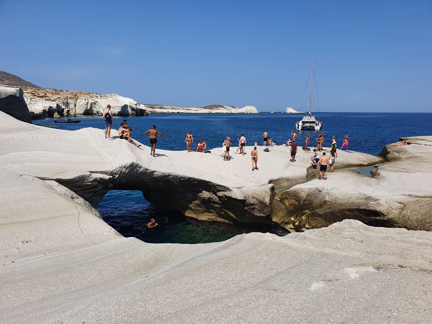 a large white rock formation next to a body of water